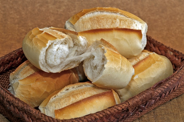 Foto cesta de pão francês em fundo de madeira rústico