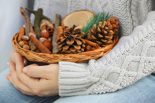 Cesta de vime com decoração de natal nas mãos da mulher, closeup