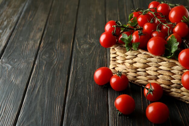 Cesta de vime com tomate cereja em madeira