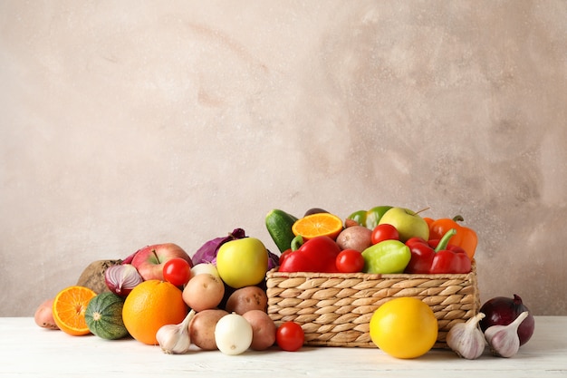 Cesta de vime, legumes e frutas em branco espaço de madeira para texto