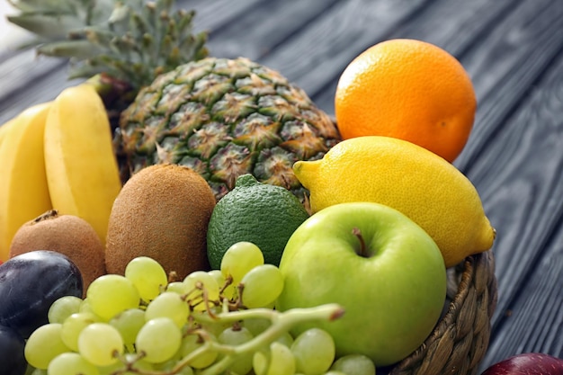 Cesta e frutas frescas na mesa de madeira