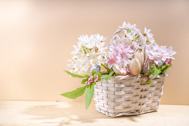 Cesta de flores de primavera sobre fondo de color cálido beige claro Vacaciones de primavera día de la madre tarjeta de felicitación espacio de copia de fondo