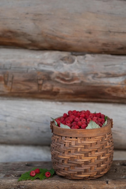 Cesta con frambuesas sobre un fondo de madera