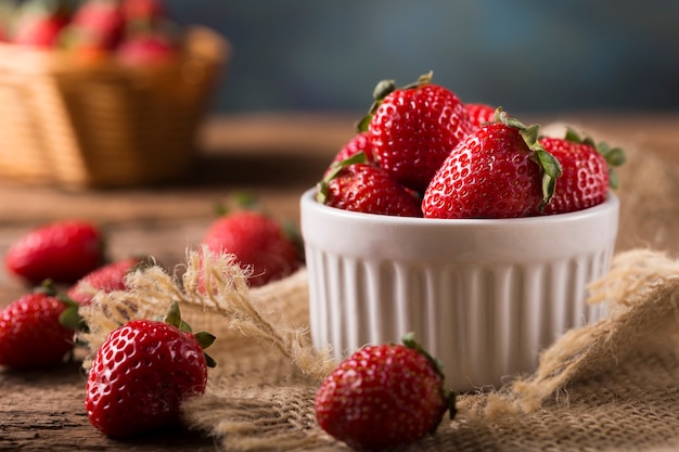 Cesta de fresas frescas sobre fondo de madera