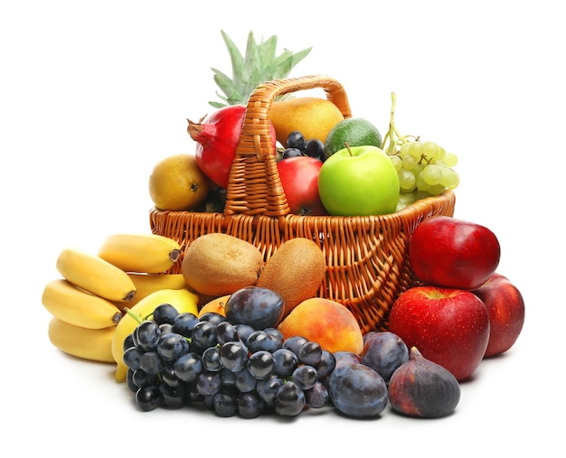 Cesta y frutas frescas sobre fondo blanco.