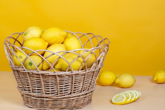 cesta llena de limones sobre un fondo amarillo