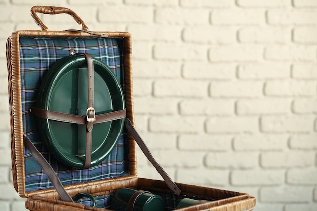 Cesta de madera para picnic con platos, tazas y cubiertos de cerca