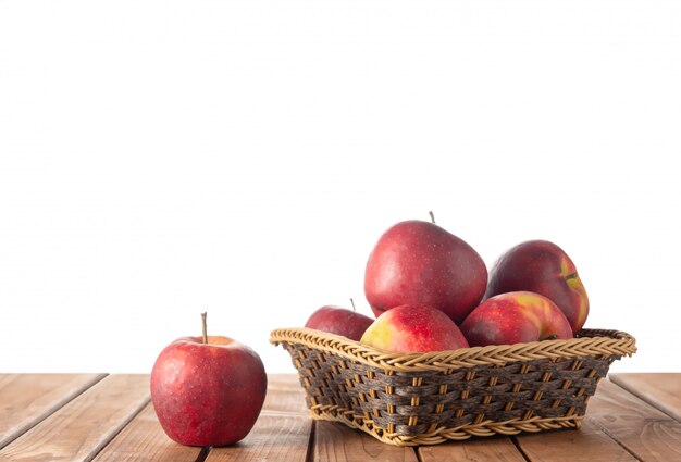 Cesta con manzanas en la mesa en blanco aislado