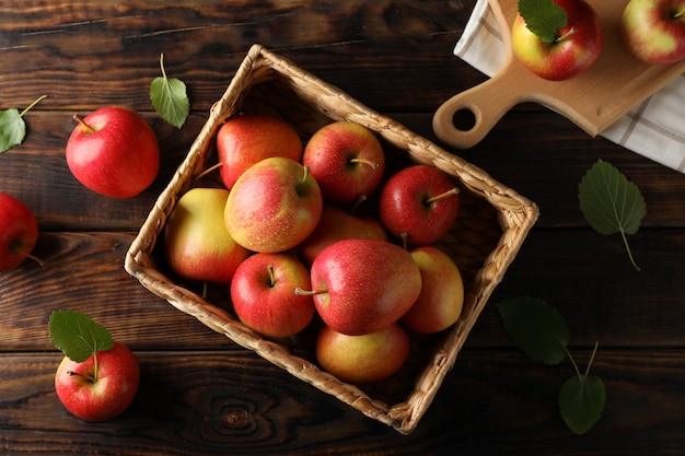 Cesta con manzanas en la mesa de madera