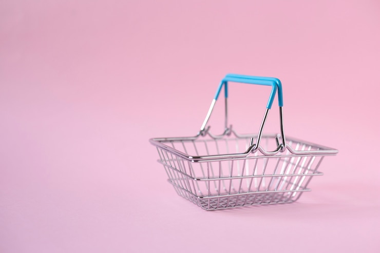 Foto cesta de metal vacía sobre fondo rosa, orientación vertical