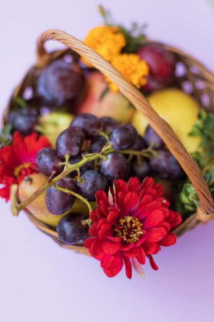 Cesta de mimbre con frutas y flores