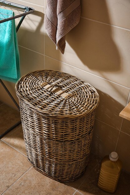 Cesta de mimbre para lavar la ropa en el baño.