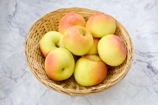 cesta de mimbre con manzanas doncellas verdes