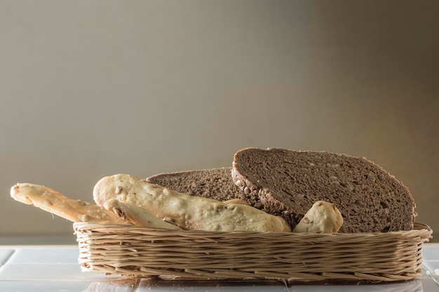 Cesta de mimbre con panecillos y rebanadas de pan de cereales pan de centeno