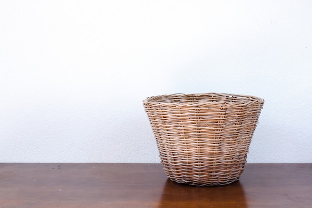 Cesta de mimbre vacía en la mesa de madera