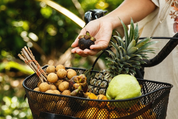 Cesta na bicicleta cheia de diferentes frutas exóticas