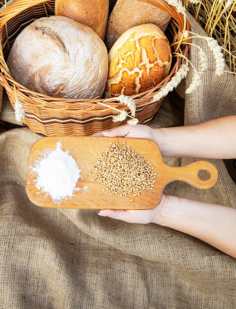 Foto cesta con pan en el fondo de las orejas de trigo cesta con pan productos de panadería en una canasta en.