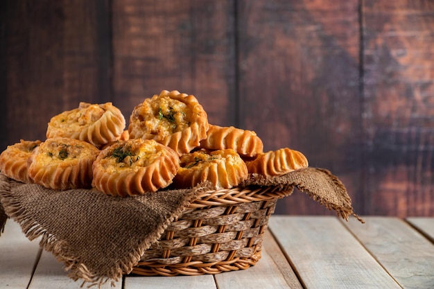 Cesta con panecillos frescos sobre fondo de madera Tortas caseras con verduras y queso Receta para plato de temporada de otoño