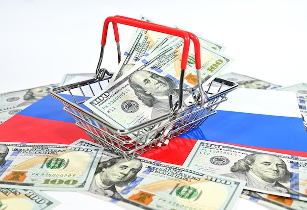 Cesta para um supermercado com dólares americanos no fundo da bandeira tricolor russa