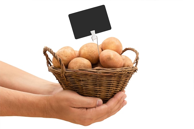 Cesta con patatas frescas y una etiqueta de precio en manos de un agricultor aislado sobre un fondo blanco.