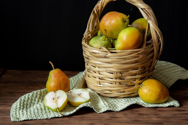 Cesta con peras en una mesa de madera