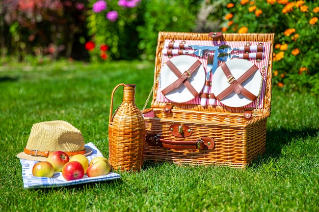 Cesta de picnic en césped verde en el parque