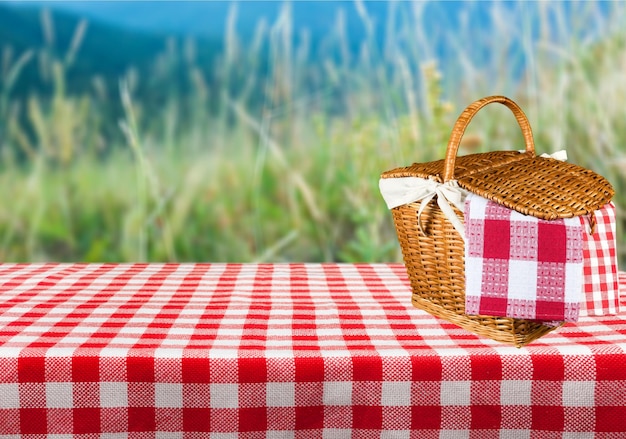 Cesta de picnic con servilleta sobre fondo de naturaleza