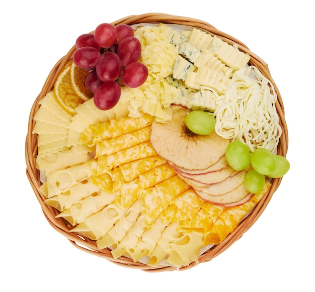 Cesta plana de vime com uma deliciosa variedade de queijo, fatias de laranja secas, maçãs secas, uvas isoladas em um fundo branco