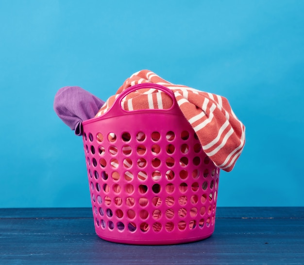 Cesta plástica rosa com roupas sujas