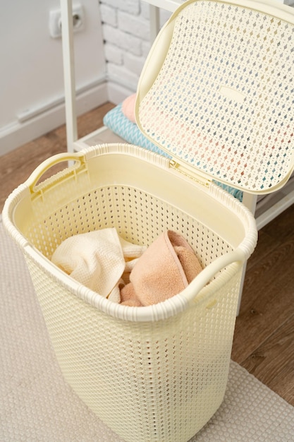 Cesta de plástico beige para lavar la ropa en una habitación