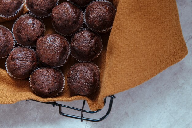 Foto cesta preta com muffins de chocolate recém-assados