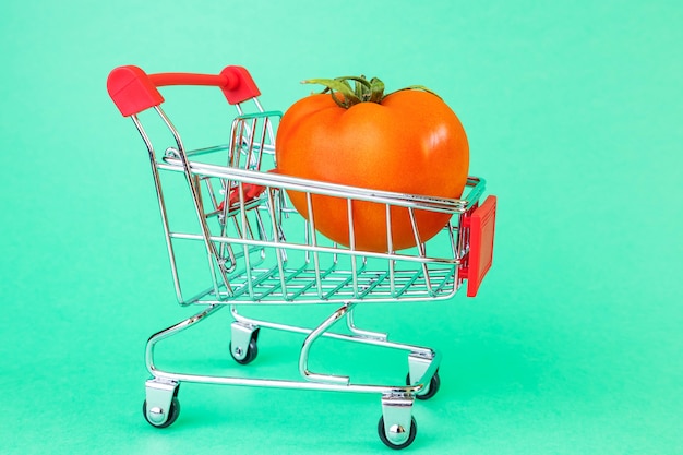 cesta de supermercado, en el interior es un tomate maduro.