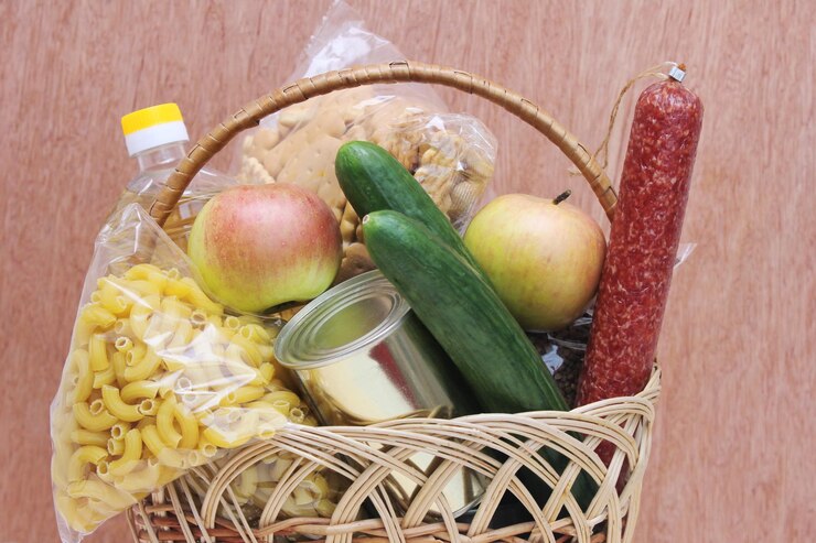 Foto cesto com comida em um fundo de madeira entrega de comida uma doação de comida