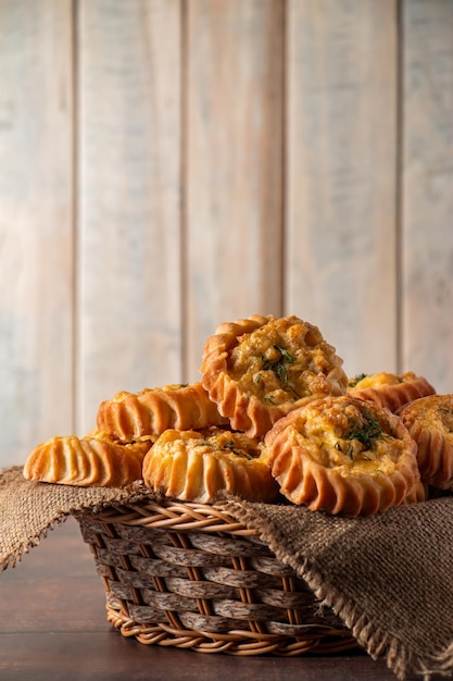 Cesto com muffins frescos sobre fundo de madeira Bolos caseiros com legumes e queijo Receita para prato sazonal de outono