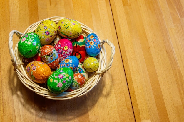 Cesto com ovos de Páscoa em mesa de madeira