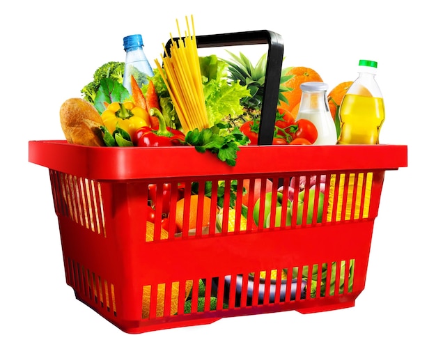 Cesto de compras vermelho de plástico cheio de vários produtos de mercearia isolados em fundo branco