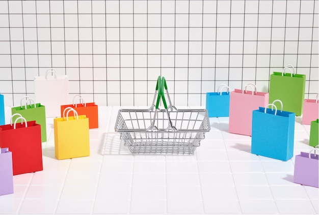 Cesto de metal vazio sacos de compras multicoloridos e espaço de cópia para texto Ideia de compras de fim de semana