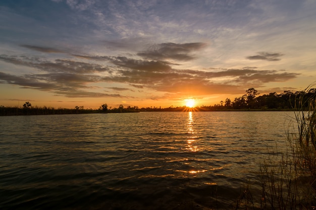 Céu alaranjado colorido bonito no por do sol sobre o lago.