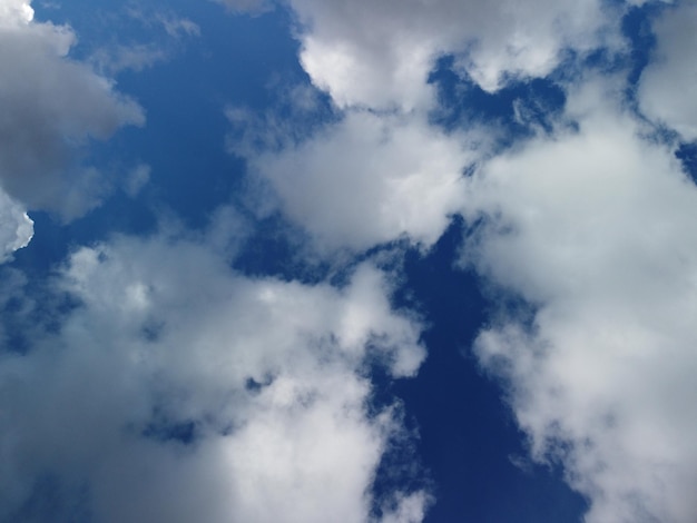 Céu arejado abstrato com nuvens gordas em movimento sobre as ondas pequenas do oceano marinho na superfície da água clara