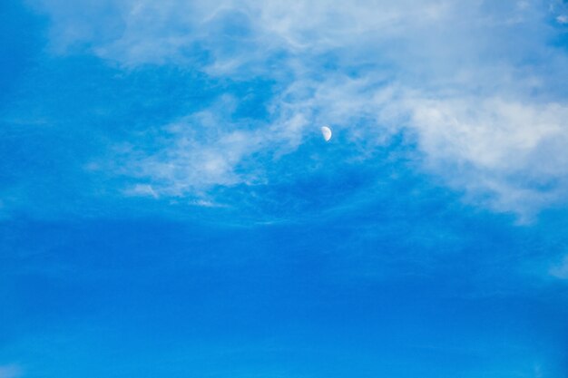 Céu azul com lua e nuvens brancas à noite