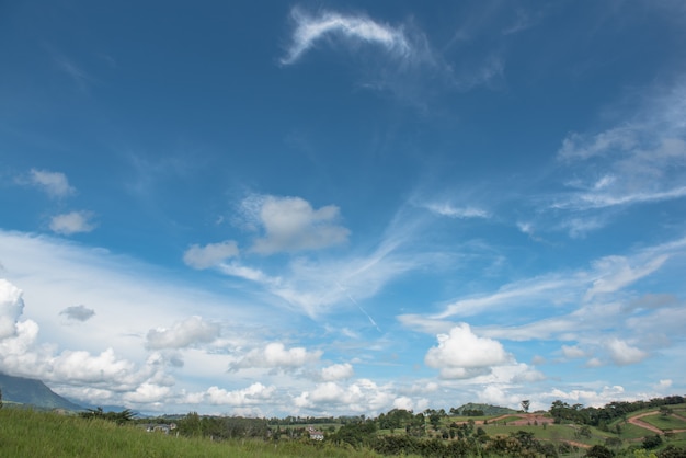 Céu azul com nuvens e paisagem inchado.