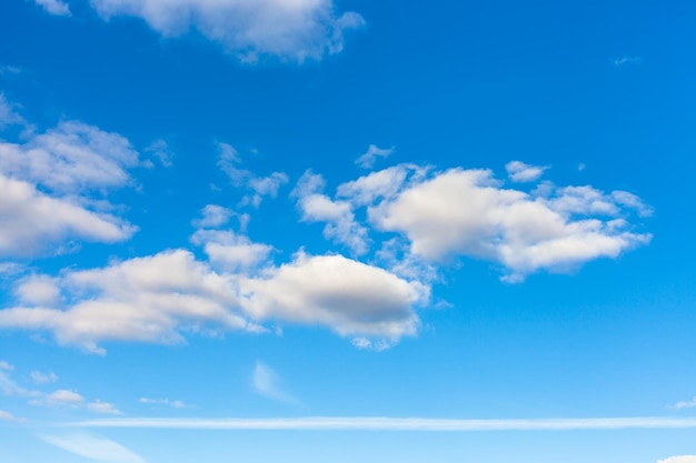 Céu azul com nuvens e trilha de avião horizontal