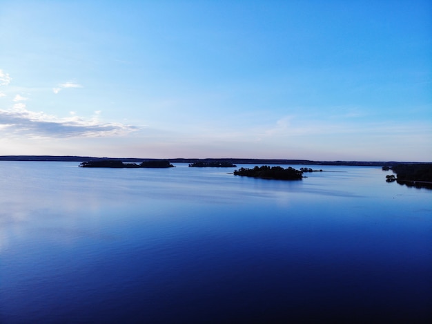 Céu azul do sol sobre o lago