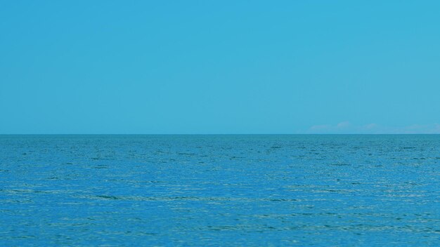 Foto céu azul e pequenas ondas suaves paisagem dramática nuvens acima do mar ou oceano