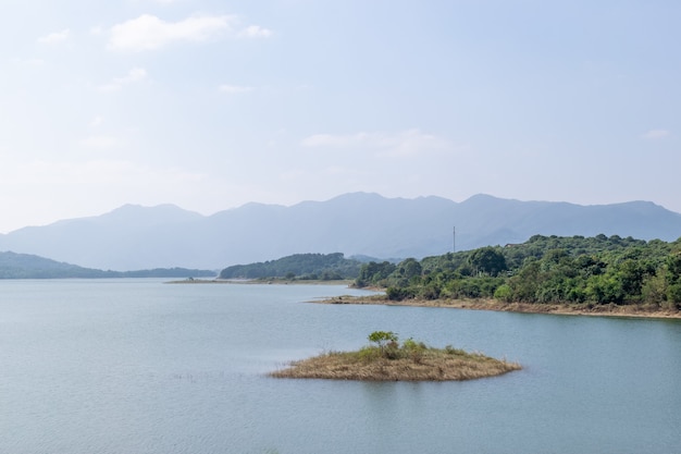 Céu azul, montanhas e árvores verdes cercam o lago