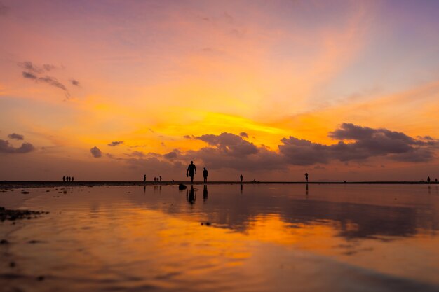 Céu brilhante queimando durante o pôr do sol em uma praia tropical.