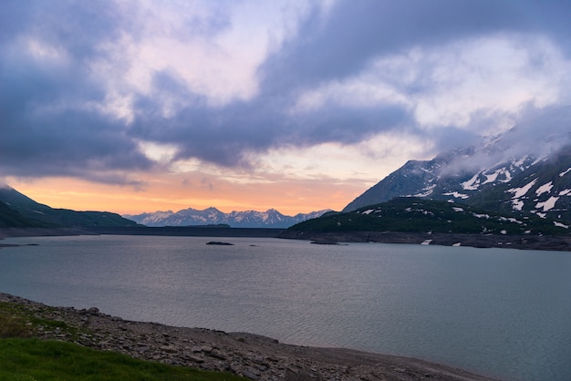 Céu cênico nuvens ao nascer do sol, lago e montanhas cobertas de neve, inverno frio, fiorde nord paisagem