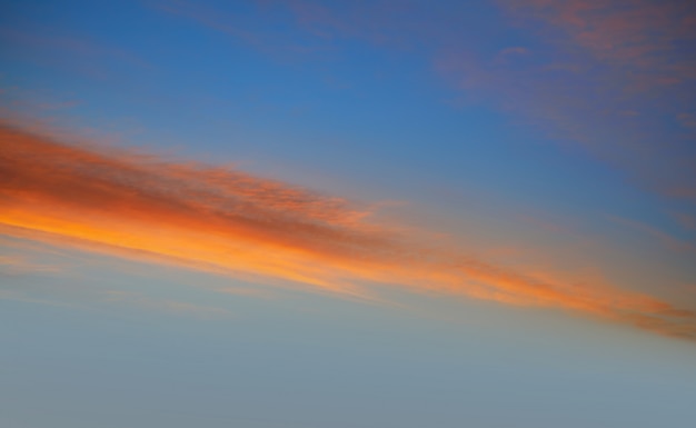 Céu de nuvens do sol em laranja e azul