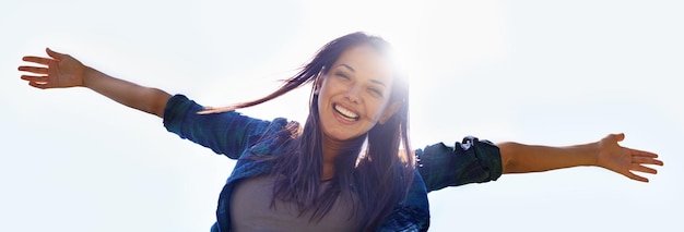 Céu de retrato e braços abertos com uma mulher ao ar livre na natureza para celebrar uma vida de liberdade financeira no verão de baixo Banner do sorriso e bem-estar com uma jovem mulher feliz com reflexo de lente