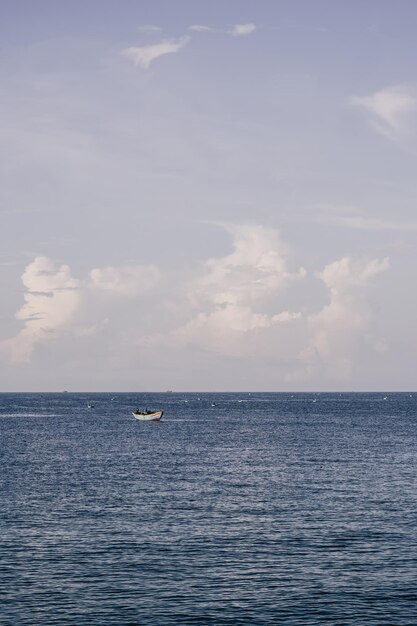 Foto céu do mar azul cumulus cloud paisagem vista de fundo água calma sozinho barco de pesca destino objetivo conceito de progresso